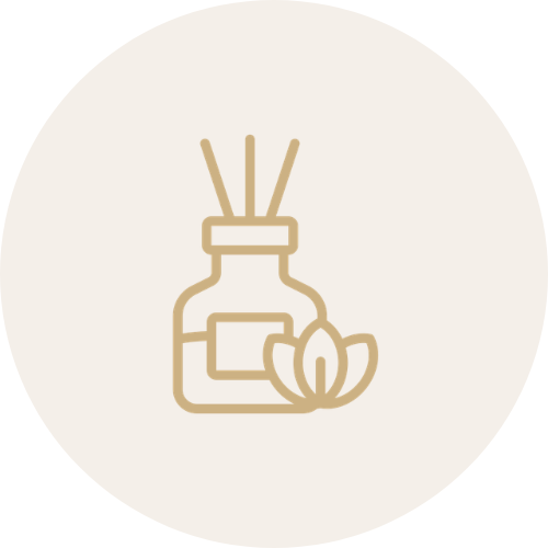 Gold icon of a diffuser bottle with reeds and a flower on a beige background