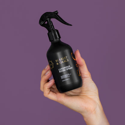 Hand holding Scarlet & Grace 250ml room spray against a purple backdrop — luxurious scented room spray Australia
